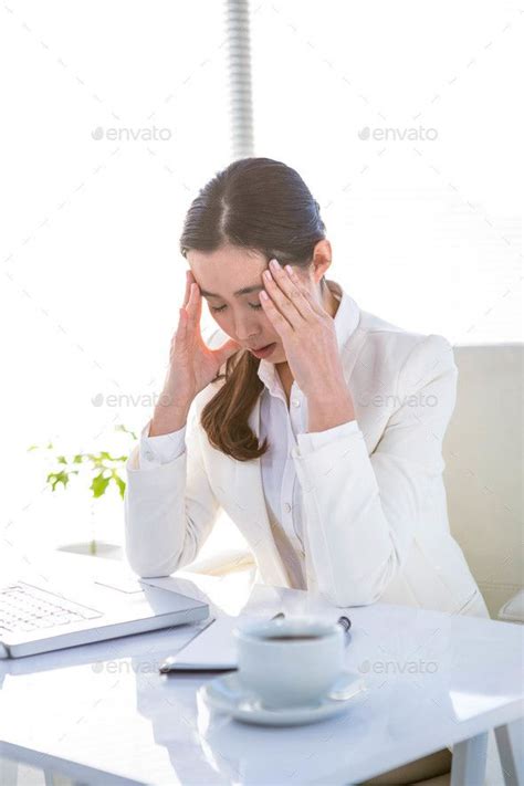 Worried Businesswoman Holding Her Head At The Desk In Work By