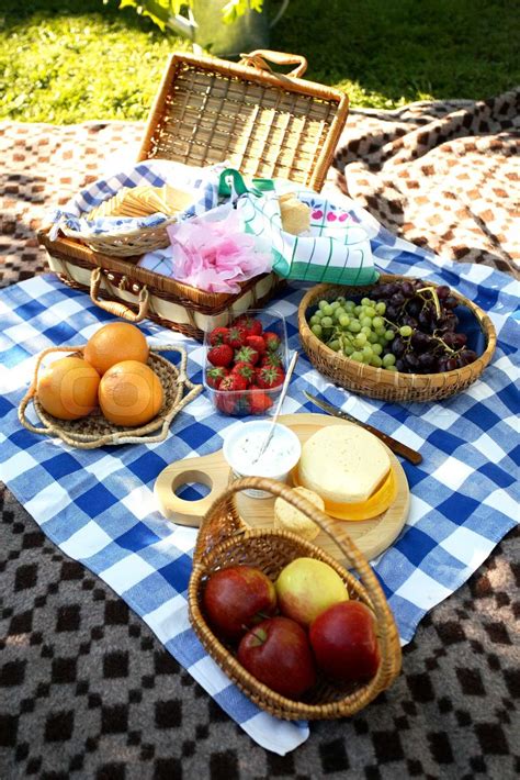 Picnic Cheese Fruits And Bread Laid On Blanket On The Ground Stock