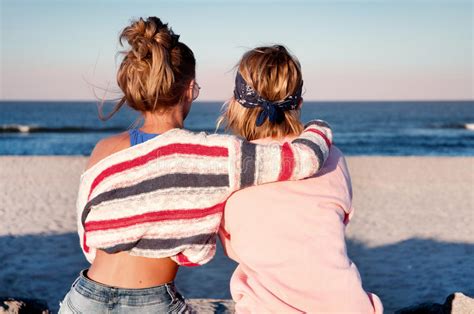 Zwei Junge Mädchen Beste Freunde Die Zusammen Auf Dem Strand An S Sitzen Stockbild Bild Von