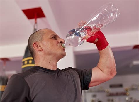 Premium Photo Fighter With Hands Wrapped Drinking Water After Training