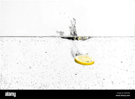 Slice Of Lemon Splashing Dropping Into Fizzy Carbonated Water Stock