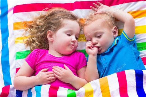 Niños Durmiendo Bajo Una Manta Colorida Fotografía De Stock