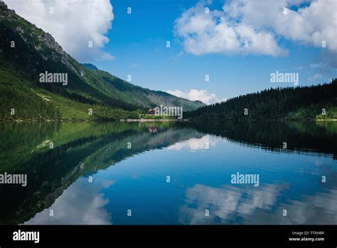 Scenic View Of Calm Morskie Oko Lake By Tatra Mountains Against Blue