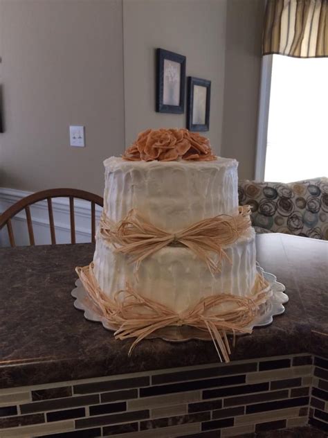 A Three Tiered Cake Sitting On Top Of A Counter Next To A Wooden Table