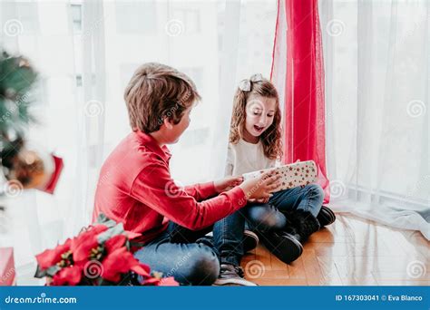 bror och syster som leker och har kul hemma av julgranen familjetid julkonceptet fotografering