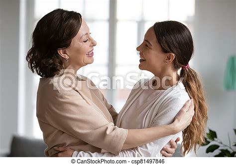 Smiling Middle Aged Mom And Grownup Daughter Hugging At Home Happy Middle Aged 60s Mother And