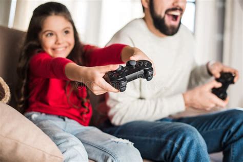 Cropped Image Of Father And Daughter Playing Video Game Stock Photo