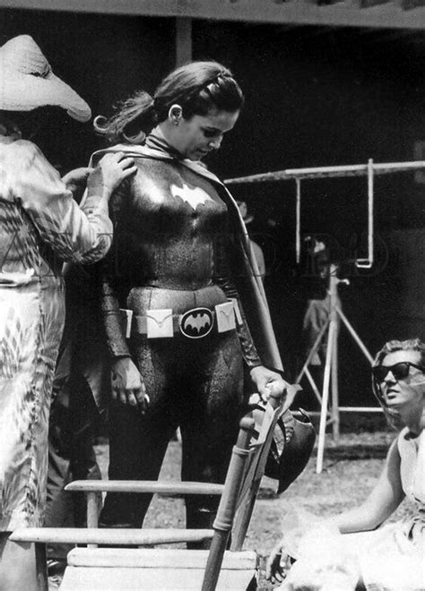 Two Women Dressed As Batman And Batgirl Standing Next To Each Other In