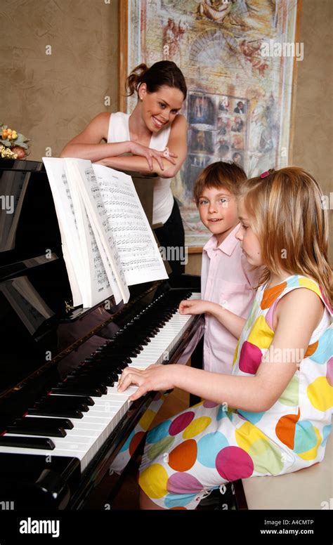 Mother Looking At Her Children Playing Piano Stock Photo Alamy