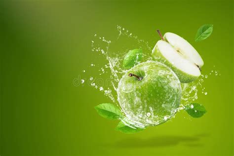 Water Splashing On Fresh Green Apple On Green Background Stock Image