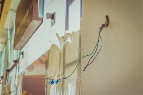Electrical Exposed Connected Wires Protruding From Socket On White Wall