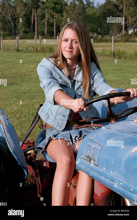 eine schöne blonde landmädchen einen traktor zu fahren stockfotografie alamy