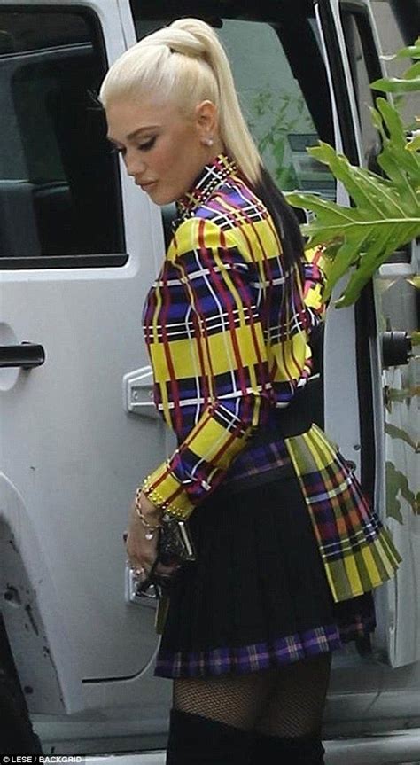 A Woman With Blonde Hair Wearing A Plaid Jacket And Black Skirt
