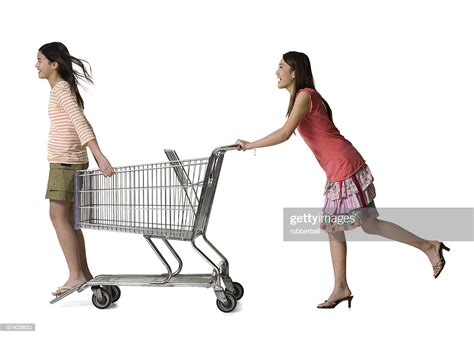 Profile Of A Young Woman Pushing A Teenage Girl In A Shopping Cart