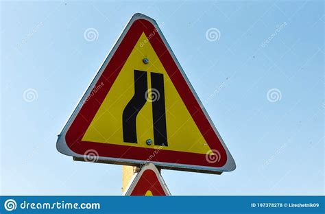 Road Narrowing Sign In A Yellow Red Triangle On The Road Stock Photo