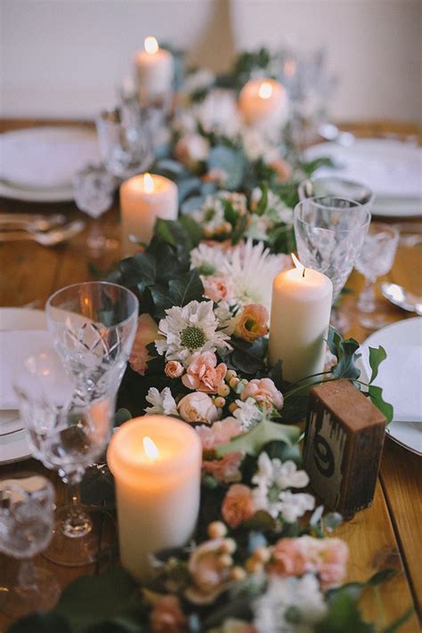 A neutral table setting with a moss runner, colorful floral centerpieces to spruce up long tables a wooden plank runner with centerpieces, candles and even nuts is a creative idea for a long table lush greenery and white bloom centerpieces and tall thin candles highlight the length of the tables Relaxed Vintage Boho Wedding Inspiration | Wedding ...