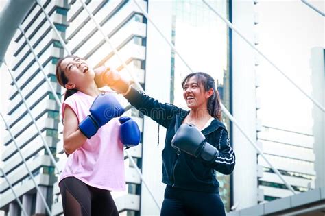 Two Asian Women Wear Boxing Gloves For Exercising Outdoors Stock Image