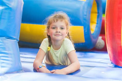 Disheveled Five Year Old Girl Is Playing On Big Inflatable Trampoline