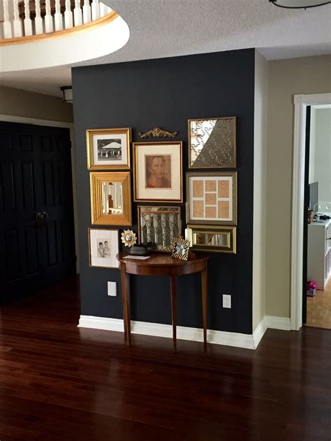 Benjamin Moore Wrought Iron gallery wall with gold frames | Black accent wall living room ...