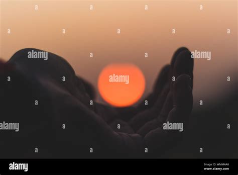 Optical Illusion Of Hand Holding Sun At Sunset Stock Photo Alamy