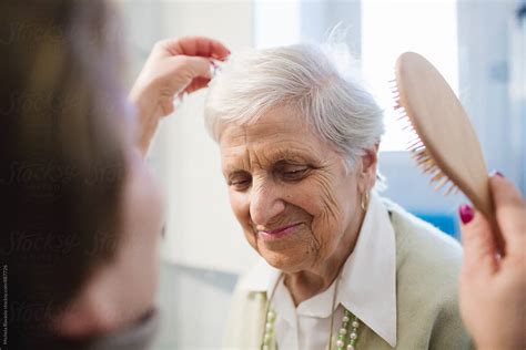 A Caregiver Brush The Hair Of An Elderly Lady Del Colaborador De