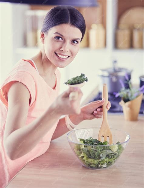 Premium Photo Smiling Young Woman Mixing Fresh Salad In The Kitchen
