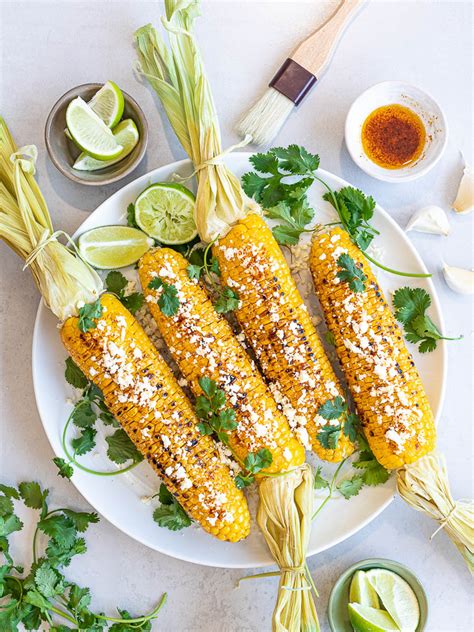 Mexican street corn is a staple of summer and it's easy to make at home! Healthy Grilled Mexican Street Corn (Elotes) with Chili Lime Oil and Cotija Cheese - Drive Me Hungry