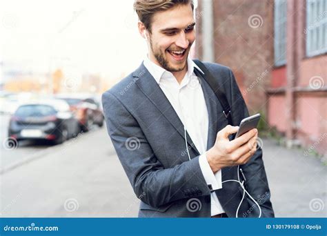 Happy Attractive Young Businessman Walking And Using Mobile Phone