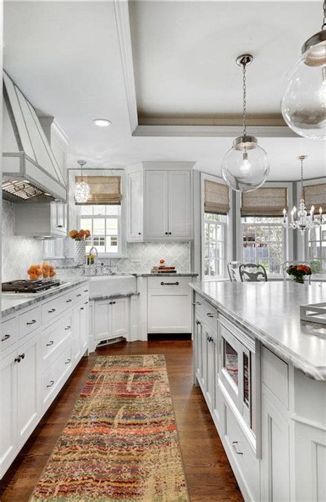 You can pair antique white kitchen cabinets with a lot of other details and elements to create specific looks that will, of course, give impact to the whole kitchen area. White kitchen - grey marble - Clear glass globe lighting ...