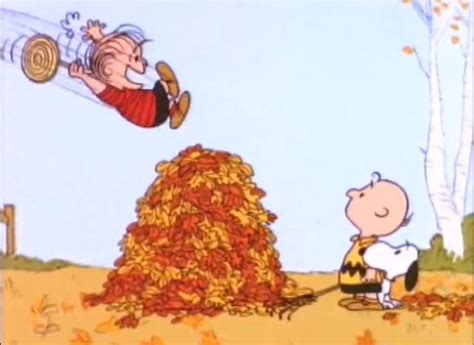 A Charlie Brown Cartoon Is Flying Over A Pile Of Leaves And Another