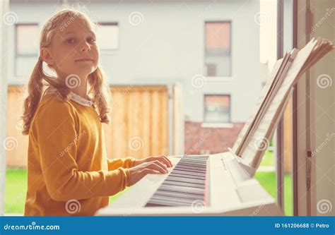 Portrait Of Pretty Little Girl Having Piano Lesson At Modern White E