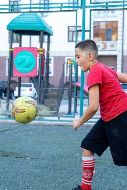 Premium Photo A Boy Kicking A Football In Leg