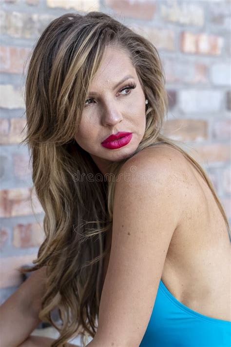 Hot Blonde Brazilian Model Posing Outdoors Against A Brick Wall Stock