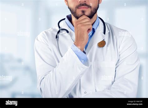 Doctor Standing With Hand On Chin Stock Photo Alamy