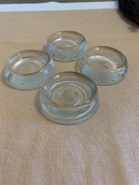 Four Glass Dishes Sitting On Top Of A Beige Tablecloth Covered Table