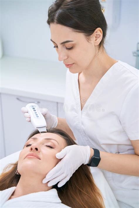 Dermatologist Cleans The Skin Of The Patient Face With An Ultrasound
