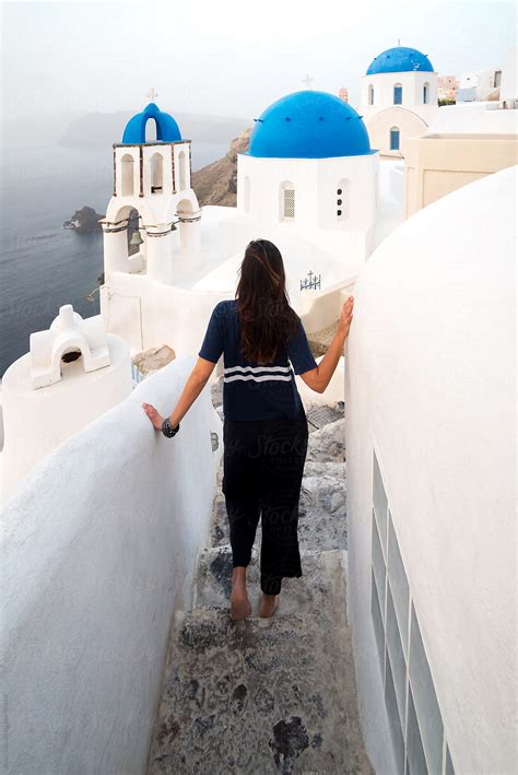 Tourist Walking On The Streets Of Oia In Santorini Greece By Stocksy