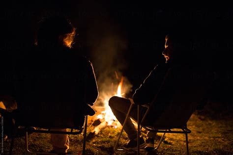 Two Friends Sitting Around Campfire By Stocksy Contributor Boris