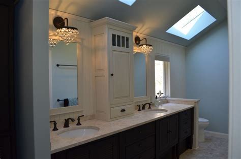 A dark brown double vanity completes this contemporary bathroom balancing out the light neutral color pallet used throughout the space. tower in center of bath vanity | Crystal Cabinetry 2-tone ...