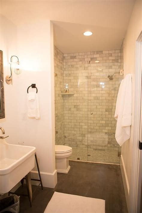 A Bathroom With A Walk In Shower Next To A White Toilet And Sink Under A Mirror