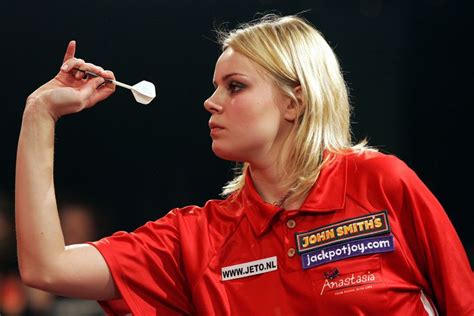 A Woman Holding A White Object In Her Right Hand And Pointing To It