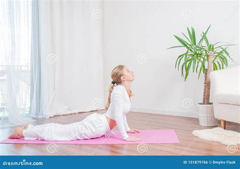 Beautiful Woman Is Practicing Yoga At Home On Yoga Mat Doing Cobra Exercise Bhujangasana Pose