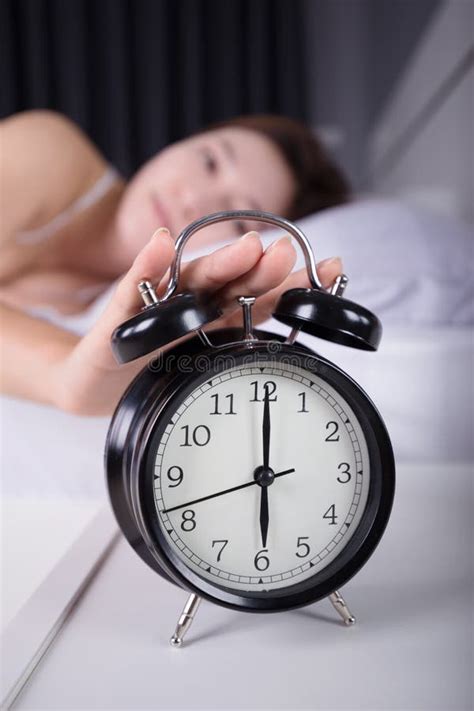 Woman Sleeping And Wake Up To Turn Off The Alarm Clock In Morning Stock