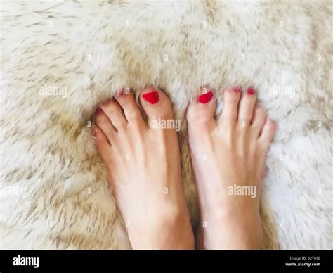 A Womans Beautiful Feet With Painted Red Toenails On A Soft Fluffy