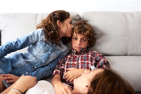 Sister Kissing Her Brother On Sofa By Stocksy Contributor Guille
