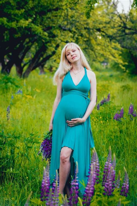 Beautiful Pregnant Woman With Flowers In The Park Paid Paid