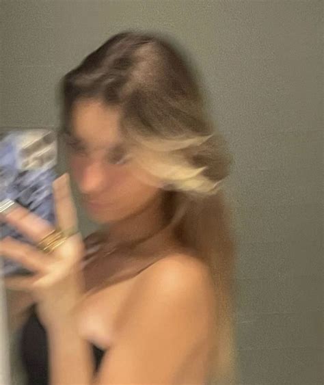 A Blurry Photo Of A Woman Holding A Cell Phone