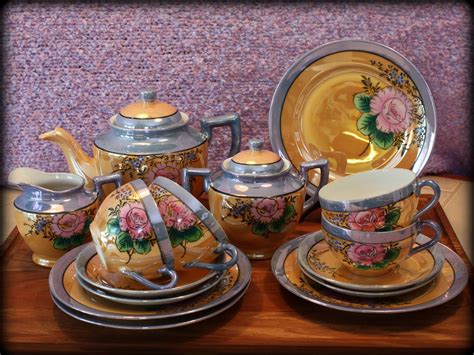 The Tea Set Is Decorated With Pink Flowers And Gold Trimmings On It S Sides