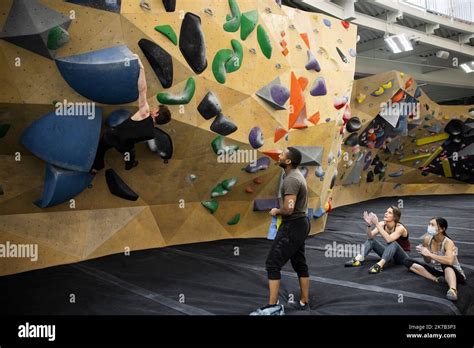 Young Climbers Cheering Friend On Wall In Climbing Gym Stock Photo Alamy