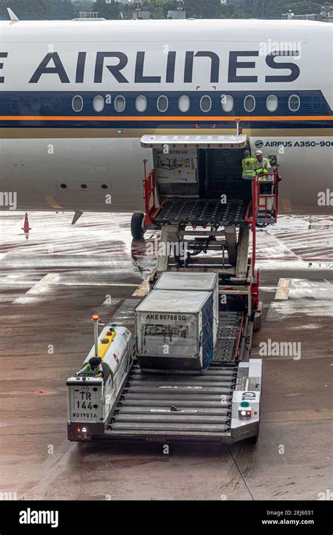 A Uld Loader Lifting A Unit Load Device Uld From Apron Dollies To An